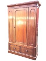 A Victorian mahogany wardrobe, the ogee cornice above an arched panelled knobbed door flanked by