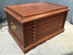 A mahogany coin cabinet with tray top above six ribbed brass knobbed fitted lined drawers, raised on