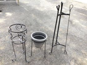 A circular wrought iron jardiniere stand with scrolled decoration to basket frame raised on three