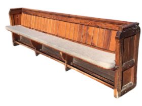 A Victorian pitch pine pew with tongue & groove boarded back above a solid seat with squab