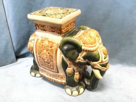 A stoneware glazed seat cast in the form of an elephant with howdah platform and harness, having