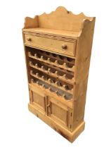 A Victorian style pine wine rack, the top with shaped back above a moulded knobbed frieze drawer and