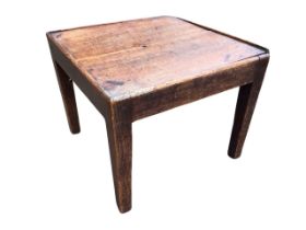 A Georgian country oak and elm low table, the square top above a plain apron, raised on tapering