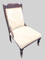A Victorian mahogany fireside chair, the shaped carved crestrail above a rectangular padded back
