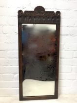 A rectangular oak framed mirror, with moulded surround surmounted by frieze & crest with chisel