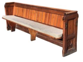 A Victorian pitch pine pew with tongue & groove boarded back, above a solid seat with squab cushion,