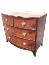 A regency mahogany bowfronted chest of drawers with crossbanded top above two short and two long