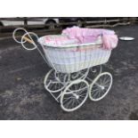 A Victorian style wicker perambulator, the oval basket body with fabric lining and frilled hood on a