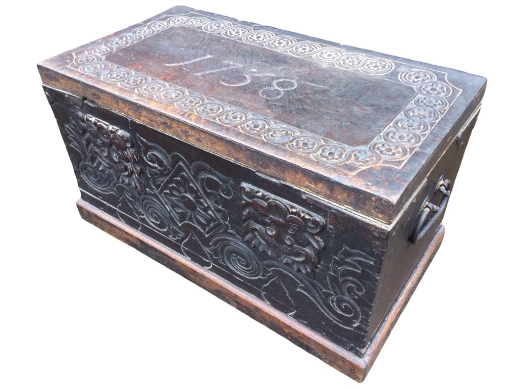 A Victorian carved oak coffer with naïve scrolled decoration, having twin applied lionmask mounts to