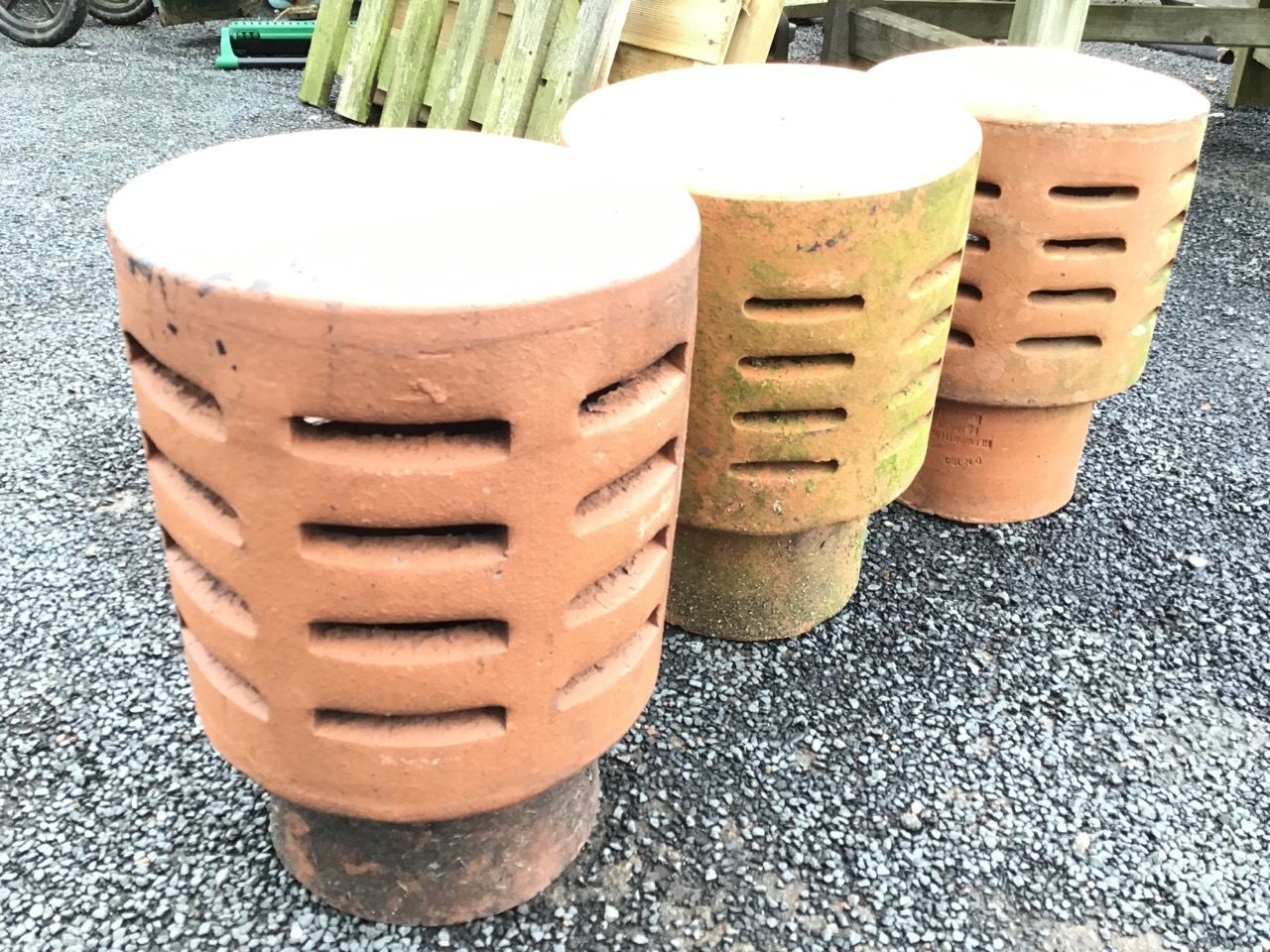 Three terracotta chimney cowls of tubular form with domed tops above slit-vented bodies. (13.5in) ( - Image 2 of 3