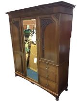 An Edwardian mahogany art nouveau combination wardrobe with moulded cornice above a central