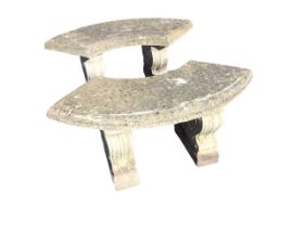 A pair of composition stone garden benches with crescent shaped moulded slab seats on scrolled