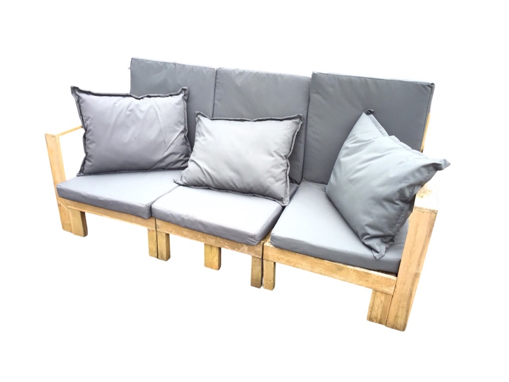 A 6ft hardwood garden bench of slatted construction, with loose cushions and platform arms, raised