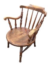 A Victorian hardwood Ibex armchair with back rail on turned supports above a solid circular seat,