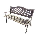 A garden bench with latticework arched metal panel to back above a wood slatted seat, the scrolled