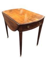 A regency mahogany oval pembroke table with two leaves opening on brackets above a bowfronted