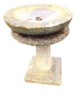 A composition stone birdbath with circular bowl on an associated panelled square tapering column