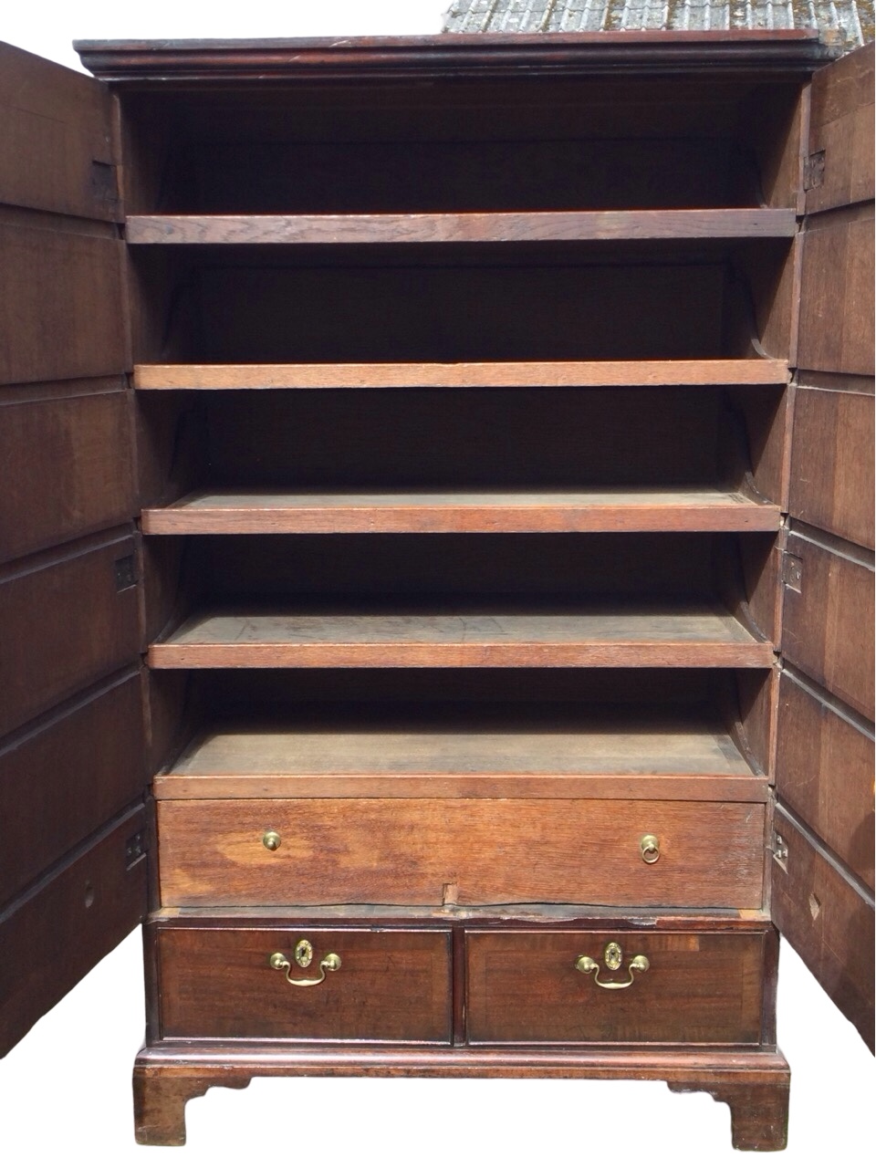 A Georgian walnut press cupboard with crossbanded doors enclosing a fitted interior with oak tray