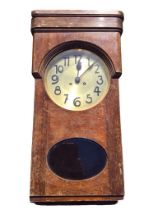 A 30s deco oak cased wallclock with brass dial and movement striking on gongs, the glazed door