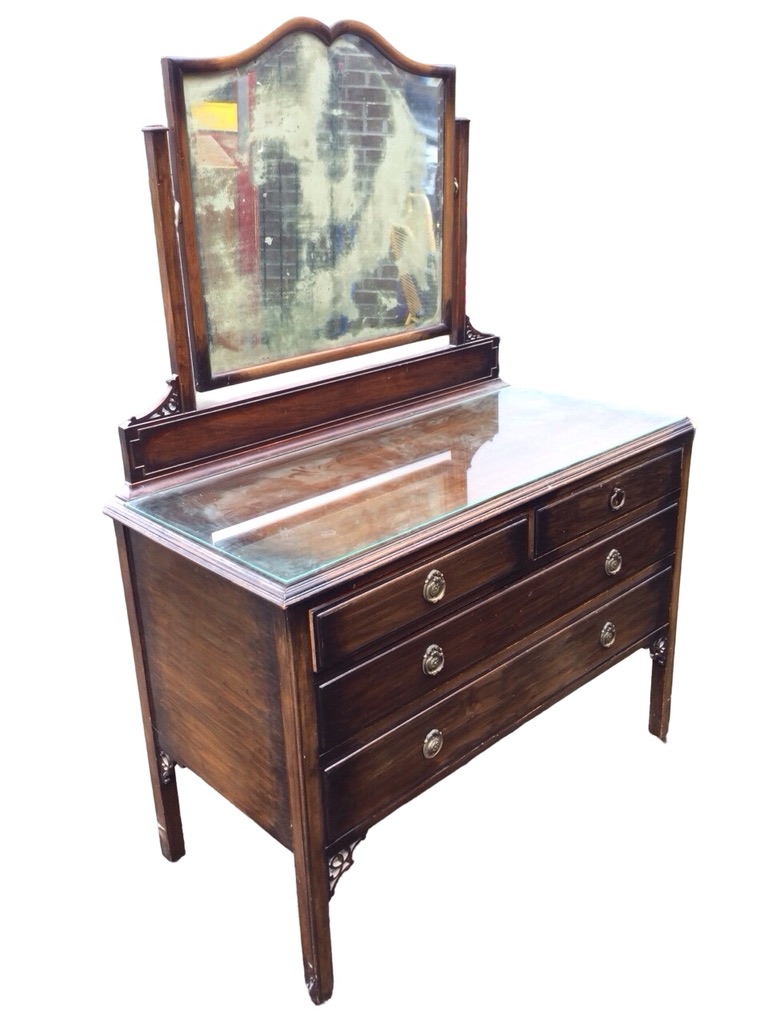 A stained mahogany dressing table with carved pierced spandrels, the scalloped framed bevelled
