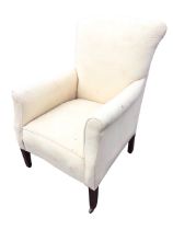 An Edwardian upholstered armchair with arched back and rectangular sprung seat flanked by