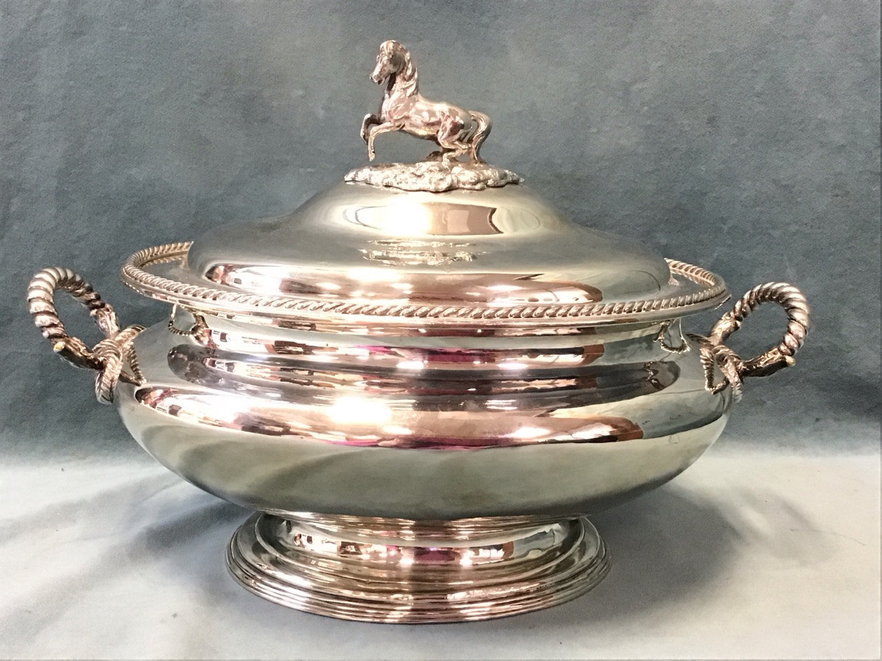 A large nineteenth century oval silver plated tureen & cover with gadrooned rim and handles, the lid