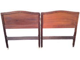 A mahogany single bed with arched panelled head and foot boards, raised on rounded rectangular