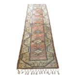 A Turkish wool runner with floral lozenges on a pink field within stylised meandering floral
