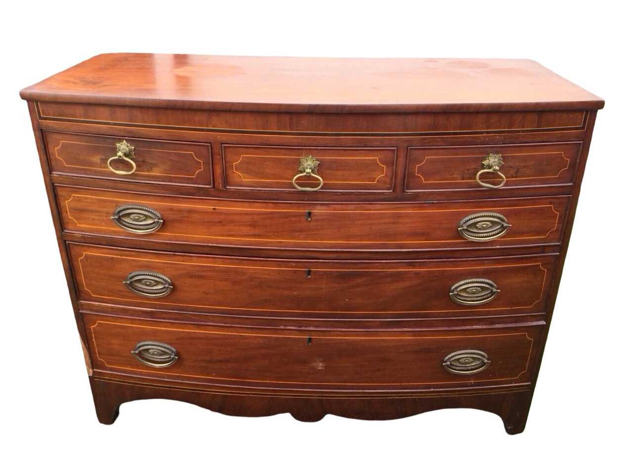 A nineteenth century bowfronted mahogany chest inlaid with boxwood stringing, having three short and