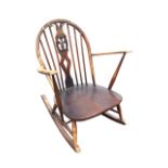 An Ercol elm & beech rocking chair with arched spindled back and Prince of Wales feather pierced