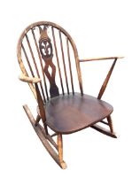An Ercol elm & beech rocking chair with arched spindled back and Prince of Wales feather pierced