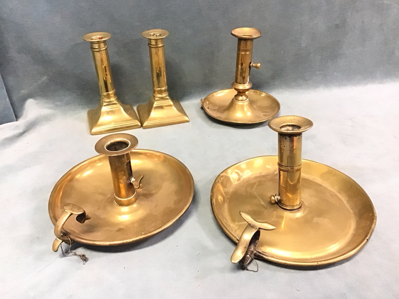 A pair of Georgian brass columnar candlesticks on flared square bases - 5.25in; and three nineteenth