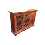 A Georgian style mahogany side cabinet with dentil cornice above a pair of astragal glazed doors and