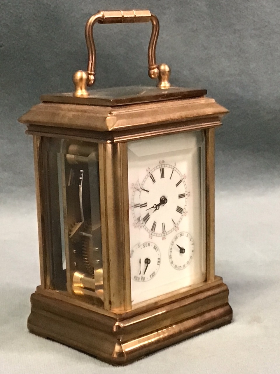 A miniature gilt brass corniche cased carriage clock with bevelled glass panels and enamelled dial