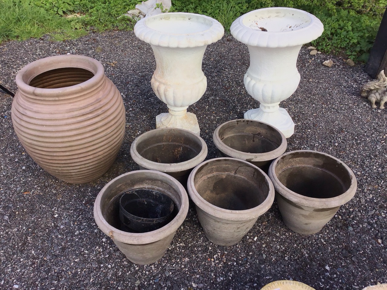 A pair of classical shaped plastic lobbed garden urns on square canted plinths; a large ribbed