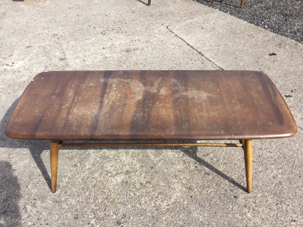 An Ercol elm & beech coffee table with rounded rectangular top raised on turned legs joined by a - Image 2 of 3