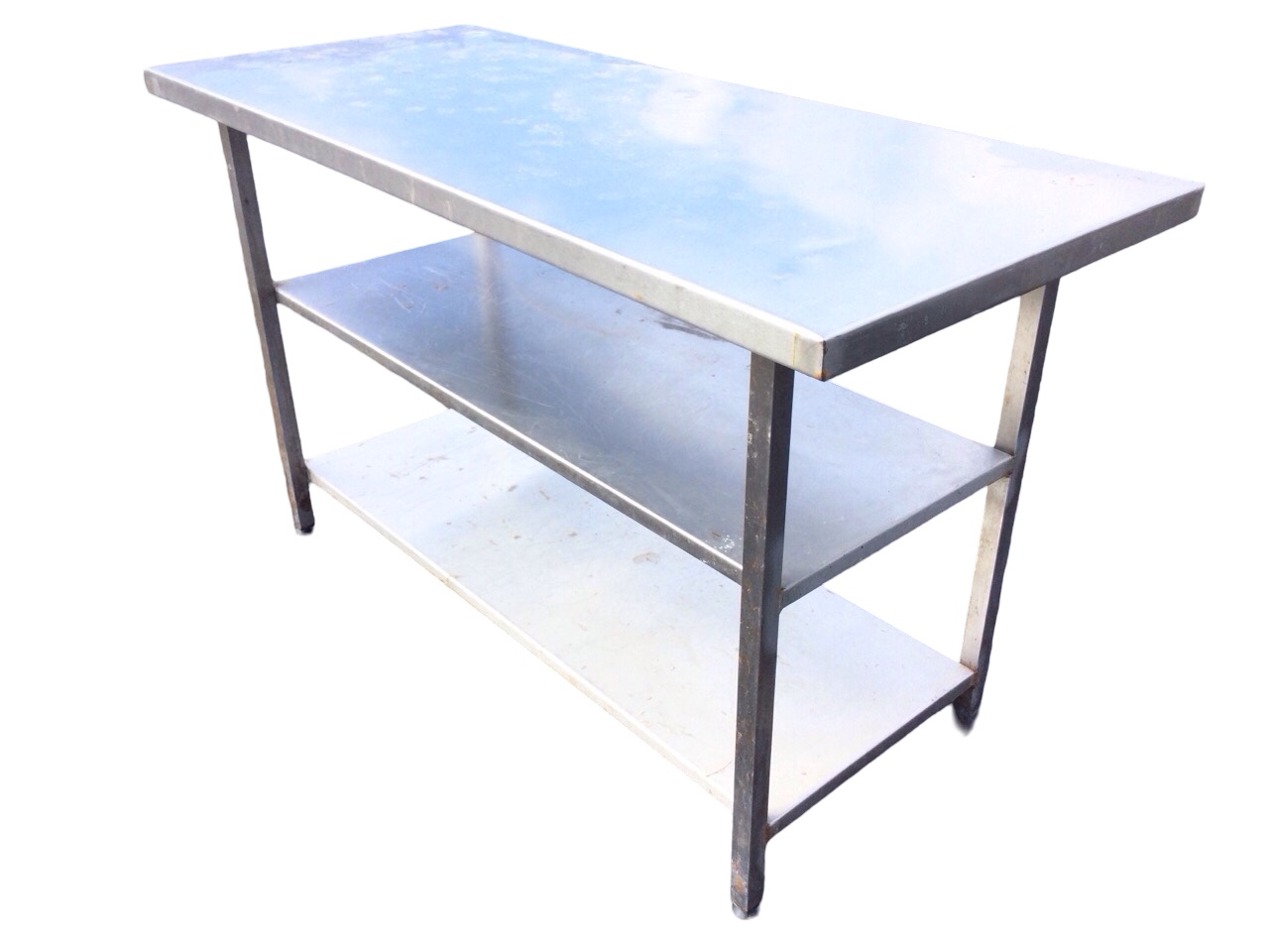 A rectangular stainless steel counter with platform top and two shelves below, supported on square