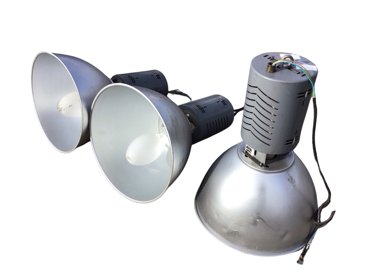 A set of three TRAC industrial lights with adjustable beams, the pierced cylindrical bodies above