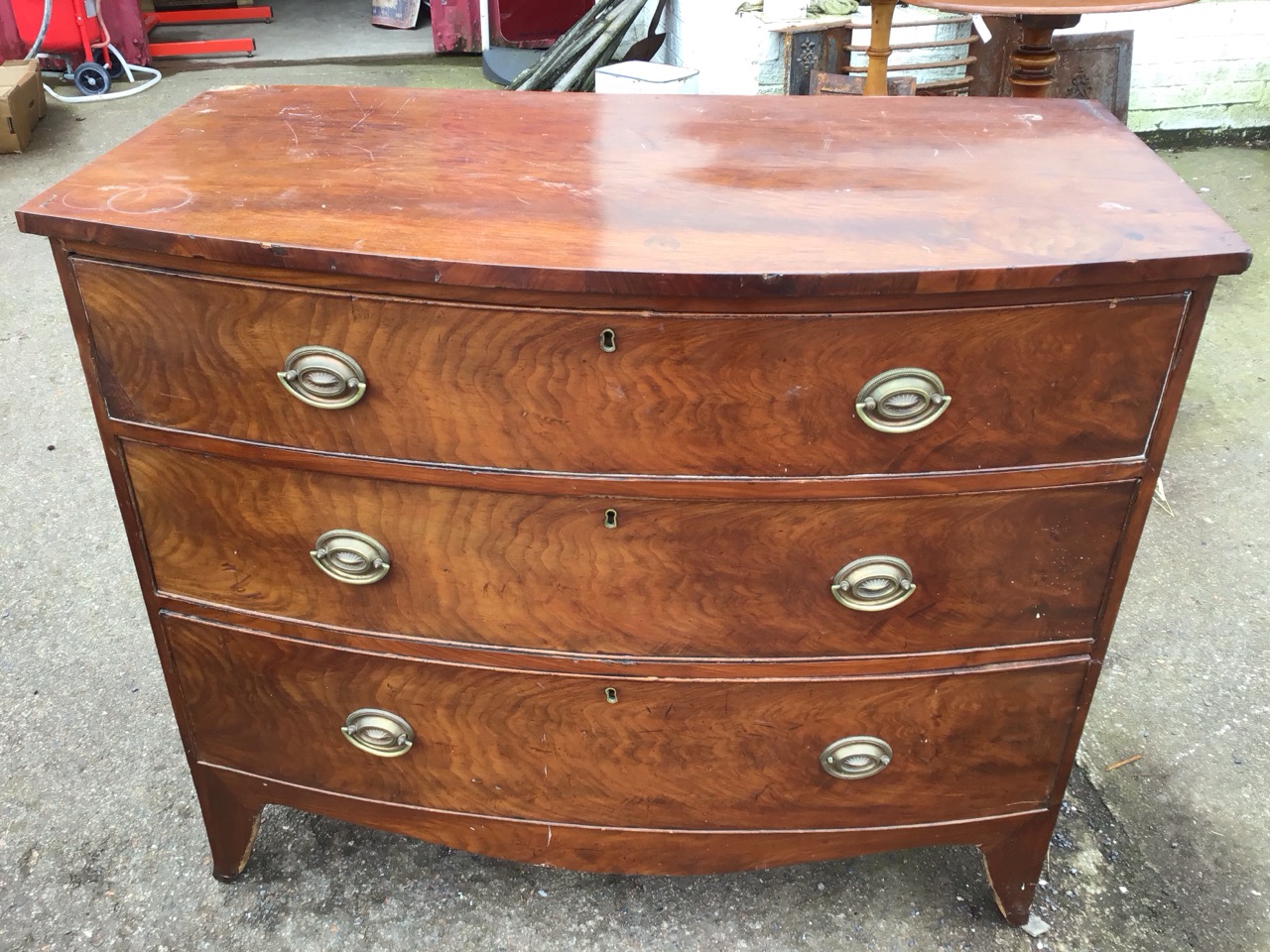 A nineteenth century mahogany bowfronted chest of three long cockbeaded drawers mounted with oval - Image 2 of 3