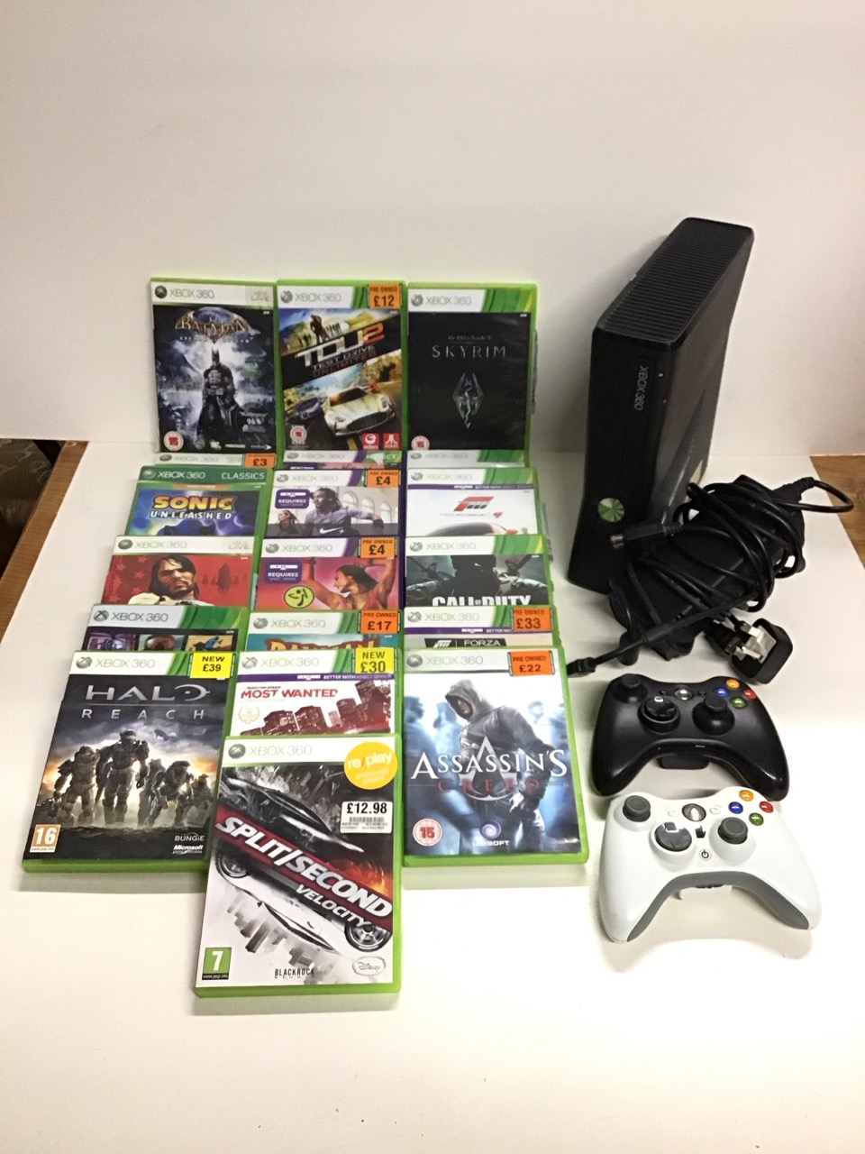 An Xbox 360 games console with AC adapter, two controllers & eighteen game discs including Halo