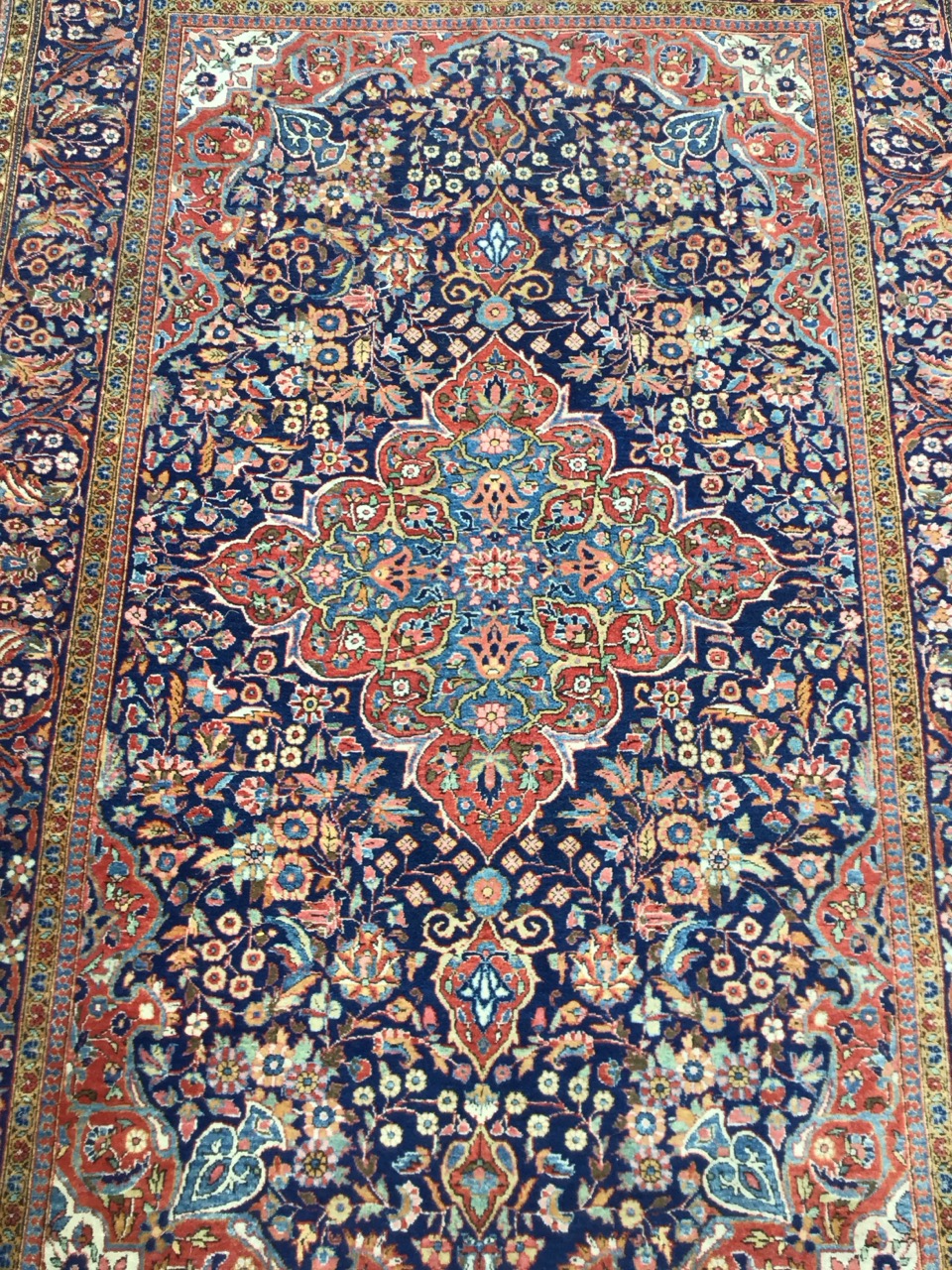 A Keshan wool rug with a quatrefoil floral medallion in a dense floral field on a blue ground, - Image 2 of 3