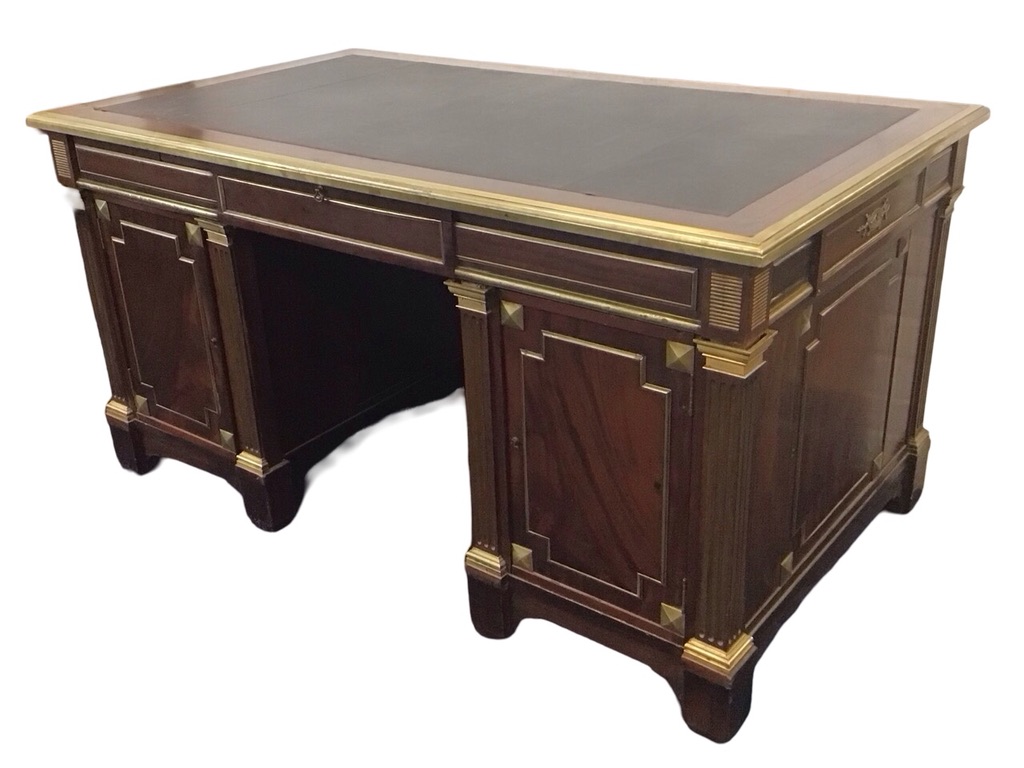 A French Empire style mahogany brass mounted desk with rectangular moulded top and leather skiver