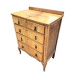 An Edwardian walnut chest of four long graduated drawers mounted with brass drop handles, the oak