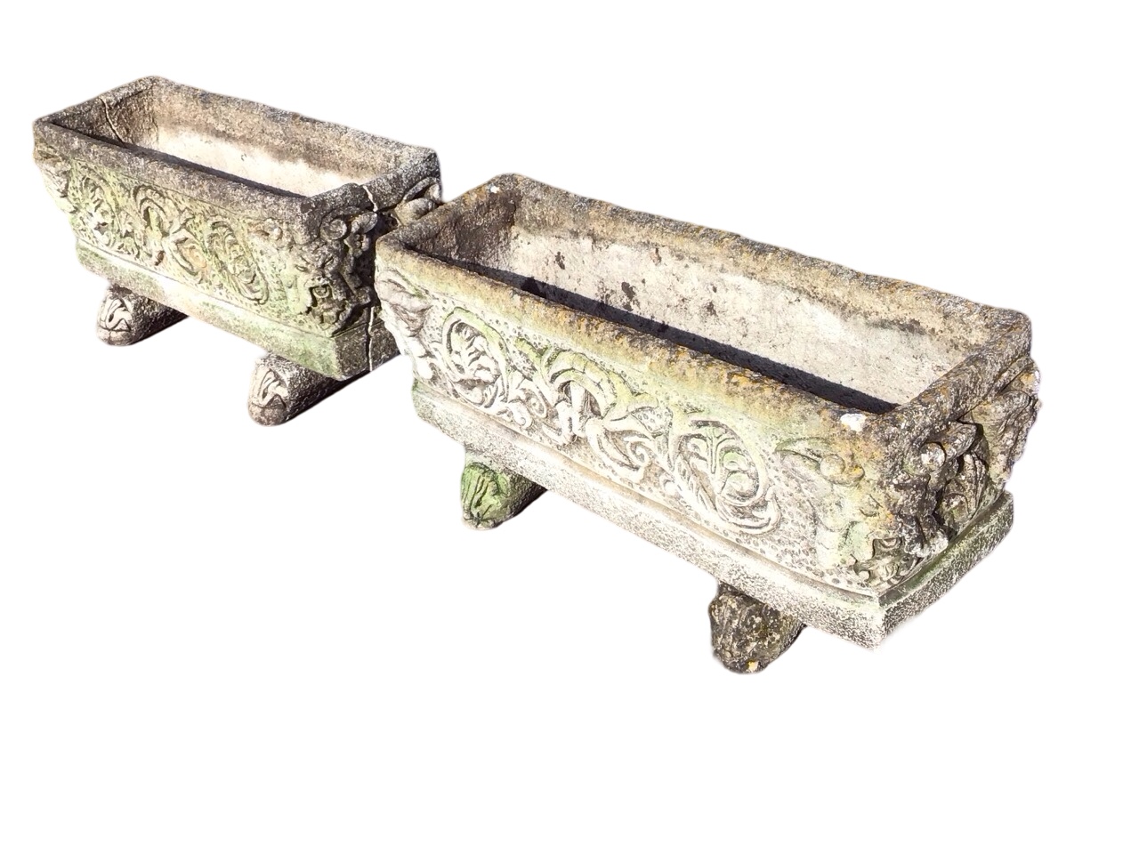 A pair of rectangular composition stone troughs with foliate scrolled moulded decoration to panelled