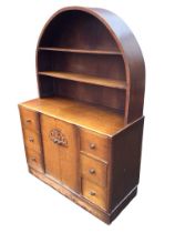 A 30s oak dresser with arched back having open shelves above a base with six small drawers framing