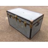 A rectangular galvanised style trunk with studded mounts and strap handles to ends, having tartan
