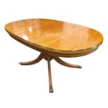 A regency style yew coffee table with moulded oval mahogany strung top on a turned column, raised on