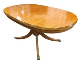 A regency style yew coffee table with moulded oval mahogany strung top on a turned column, raised on