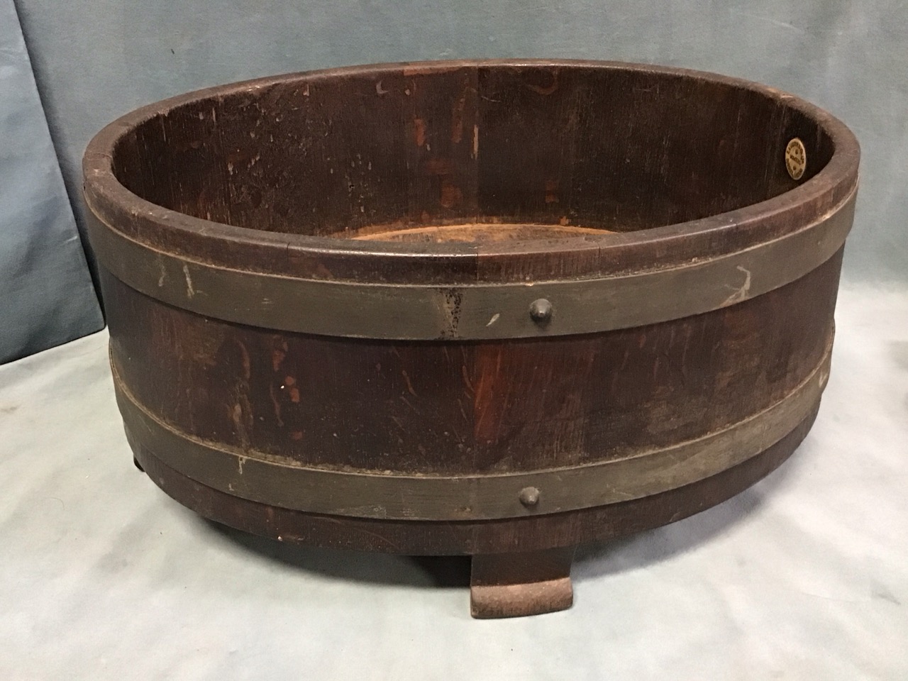 An Edwardian oval coopered oak jardiniere with copper bands, raised on shaped stile feet, by RA