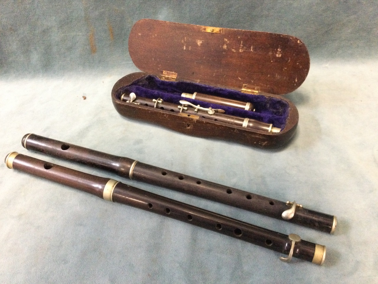 A cased Hawks & Son rosewood piccolo; another similar rosewood instrument by Hawkes; and a third